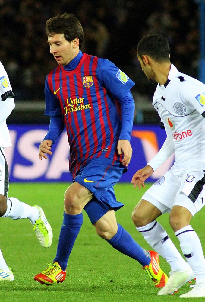 Lionel Messi dribbling in Barcelona's blaugrana stripes