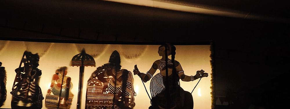 Tholpavakoothu shadow puppets lit against a glowing screen